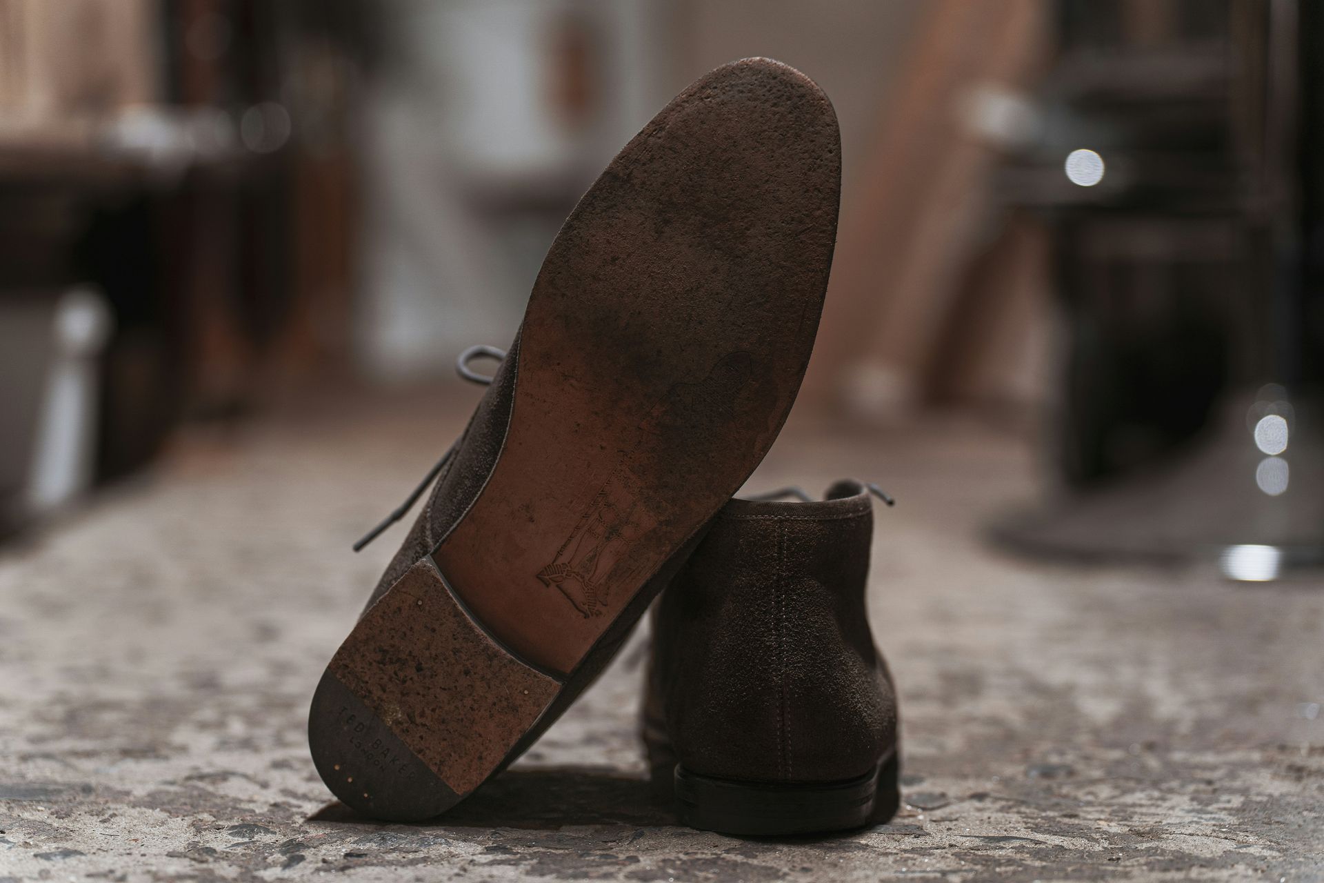 Worn brown shoe with sole visible, leaning on another.